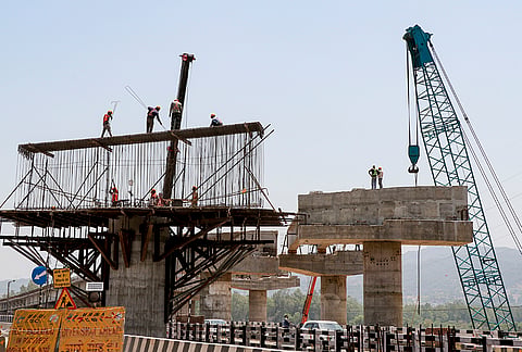 People work at a construction site along the Delhi-Amritsar-Katra Expressway on a summer day, in Jammu.
