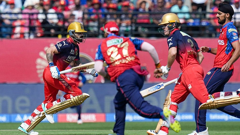Royal Challengers Bengaluru's Jacob Bethell and Virat Kohli run between the wickets during the Indian Premier League (IPL) 2026 T20 cricket match between Punjab Kings and Royal Challengers Bengaluru, in Dharamshala, Himachal Pradesh. - | Photo: PTI/Karma Bhutia