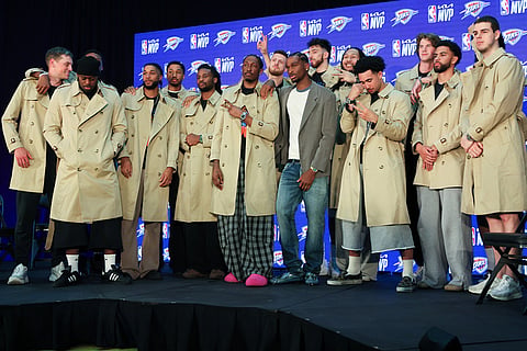 Oklahoma City Thunder guard Shai Gilgeous-Alexander, center, poses with teammates in Burberry trench coats he bought during a news conference after he was named the NBA basketball MVP in Oklahoma City.