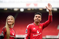 Man United 3-2 Nottingham Forest, English Premier League 2025-26: Bruno Fernandes Stars As Red Devils Seal Thrilling Win | Photo: AP/Dave Thompson : Manchester United's Casemiro leaves the pitch with his wife Anna Mariana after his last game for the club at the end of English Premier League soccer match between Manchester United and Nottingham Forest in Manchester, England.