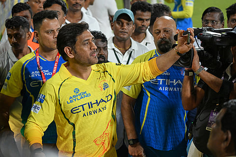 Chennai Super Kings' Mahendra Singh Dhoni with teammates takes selfies with his fans after the Indian Premier League cricket match against Sunrisers Hyderabad in Chennai, India.