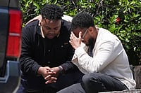 (AP Photo/Gregory Bull) : Two men embrace at the scene of a shooting outside the Islamic Center of San Diego Monday, May 18, 2026, in San Diego. 