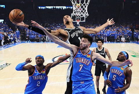 San Antonio Spurs forward Victor Wembanyama (1) and Oklahoma City Thunder center Chet Holmgren (7) reach for a rebound during the first half of Game 1 in a third-round NBA basketball playoffs series in Oklahoma City.