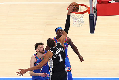 San Antonio Spurs forward Victor Wembanyama (1) shoots against Oklahoma City Thunder center Chet Holmgren (7) and guard Luguentz Dort during the second overtime of Game 1 in a third-round NBA basketball playoffs series in Oklahoma City. 
