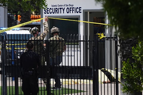 A body is covered with a tarp at the scene of a shooting outside the Islamic Center of San Diego Monday, May 18, 2026, in San Diego. 