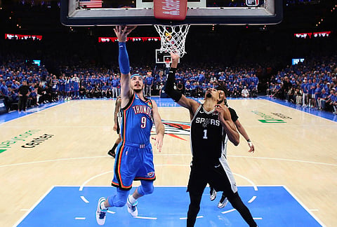 Oklahoma City Thunder guard Alex Caruso (9) shoots against San Antonio Spurs forward Victor Wembanyama (1) during the second half of Game 1 in a third-round NBA basketball playoffs series in Oklahoma City. 