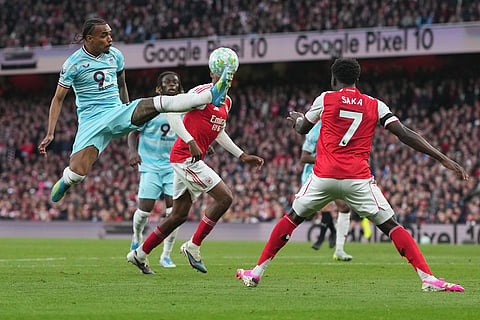 Burnley's Lucas Pires goes for the ball in front of Arsenal's Bukayo Saka during a Premier League soccer match between Arsenal and Burnley in London.
