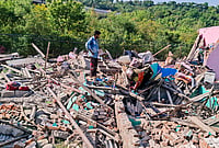 Day In Pics: May 19, 2026 | Photo: PTI : A man looks for his belongings following an anti-encroachment drive conducted by Forest Department and the police to clear alleged illegal settlements on the forest lands surrounding the lower side of Mahamaya Temple, in Jammu, Jammu and Kashmir.