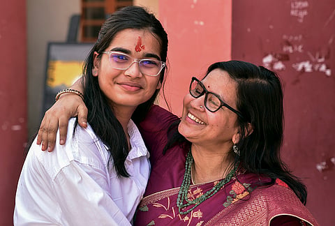 All India CBSE class 12 examination topper Tanya Sawansukha, left, poses for photographs along with Jain Public School principal Rupashree Soni after scoring 499 out of 500 marks and securing 99.80 percentage, in Bikaner, Rajasthan.