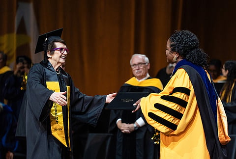 Tennis legend Billie Jean King smiles as she receives her diploma from California State University, Los Angeles, President Berenecea Johnson Eanes during commencement in Los Angeles.