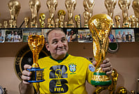 FIFA World Cup Trophies 'Weren't For Sale,' So A Brazilian Creates His Own | Photo: AP/Bruna Prado : Jarbas Meneghini Carlini poses for a photo holding FIFA World Cup trophy replicas he made, at his home in Rio de Janeiro.