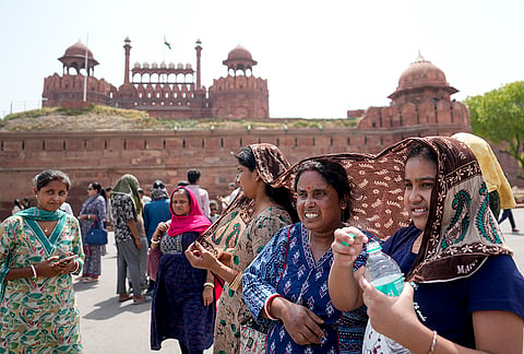 Women cover themselves on a hot summer day, at Red fort, in New Delhi. Delhi experienced a warm Tuesday morning as the minimum temperature settled at 28.2 degrees Celsius while the weather office issued a 'yellow' alert for heatwave conditions, with isolated places in the city likely to reel under intense heat during the day. 