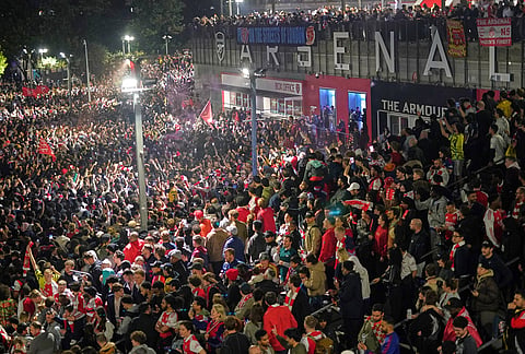 Arsenal supporters gather to celebrate at the Arsenal stadium after Arsenal's soccer team won the Premier League title in London.