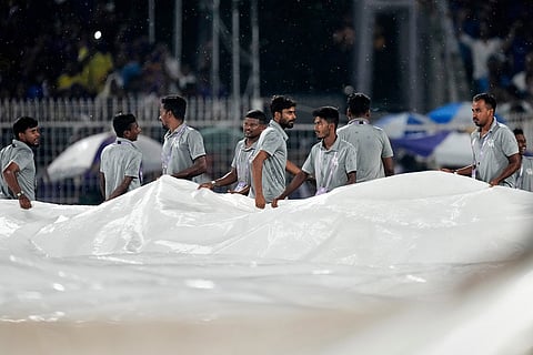 Ground staffs cover the pitch after rain stoped the play during the Indian Premier League cricket match between Kolkata Knight Riders and Mumbai Indians, in Kolkata , India, Wednesday, May 20, 2026. ()
