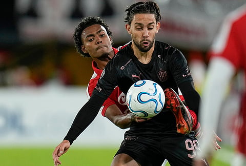 Kilian Toscano of Colombia's Independiente Santa Fe, left, and Gonzalo Lencina of Argentina's Platense battle for the ball during a Copa Libertadores Group E soccer match in Bogota, Colombia.