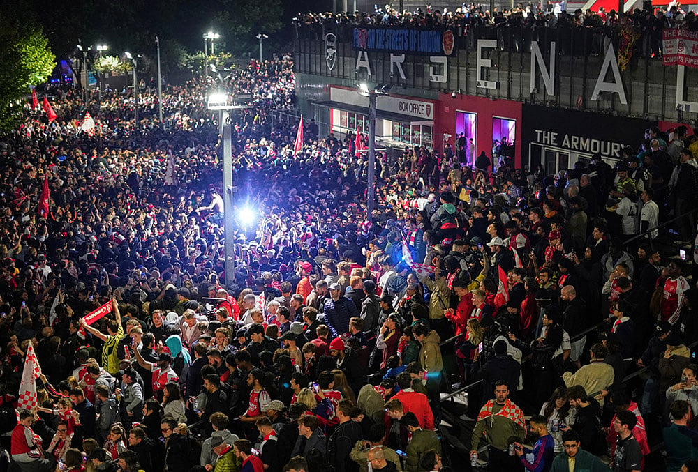 Arsenal supporters gather to celebrate at the Arsenal stadium after Arsenal's soccer team won the Premier League title in London. - | Photo: AP/Alberto Pezzali