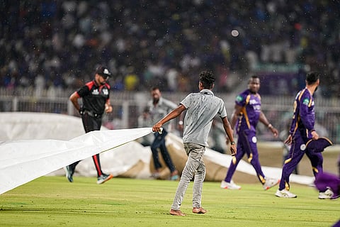 Ground staff cover the pitch due to rain during the Indian Premier League (IPL) 2026 T20 cricket match between Kolkata Knight Riders and Mumbai Indians, in Kolkata, West Bengal.