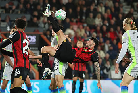 Bournemouth's Marcos Senesi, centre, kicks the ball during the English Premier League soccer match between AFC Bournemouth and Manchester City in Bournemouth, England.