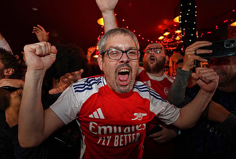 Arsenal supporters celebrate in a pub near the Arsenal stadium after Arsenal's soccer team won the Premier League title in London.