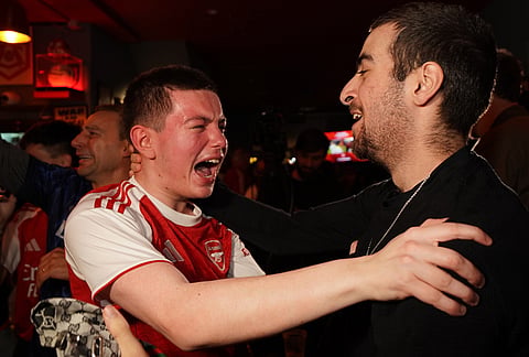 Arsenal supporters celebrate in a pub near the Arsenal stadium after Arsenal's soccer team won the Premier League title in London.