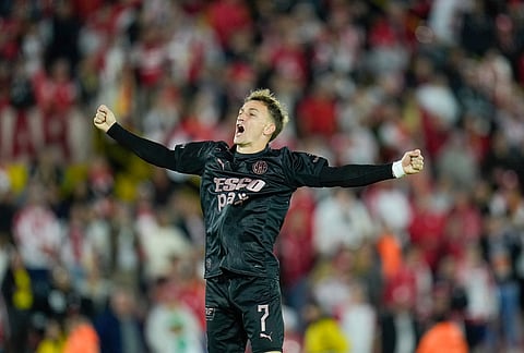 Guido Mainero of Argentina's Platense celebrates his side's first goal scored by teammate Augusto Lotti during a Copa Libertadores Group E soccer match against Colombia's Independiente Santa Fe in Bogota, Colombia.