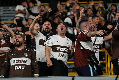 Fans of Argentina's Platense cheer prior to the start of a Copa Libertadores Group E soccer match against Colombia's Independiente Santa Fe in Bogota, Colombia.
