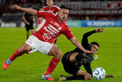 Mateo Puerta of Colombia's Independiente Santa Fe, left, and Ivan Gomez of Argentina's Platense battle for the ball during a Copa Libertadores Group E soccer match in Bogota, Colombia.