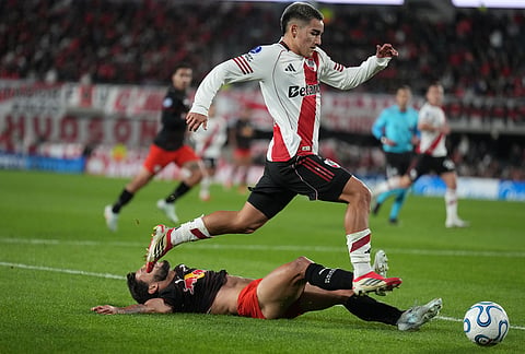 Ian Subiabre of Argentina's River Plate controls the ball as Juninho Capixaba of Brazil's Red Bull Bragantino falls during a Copa Sudamericana Group H soccer match in Buenos Aires, Argentina.