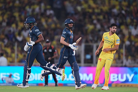 Chennai Super Kings' Mukesh Choudhary, right, watches as Gujarat Titans' captain Shubman Gill and Sai Sudharsan, left, run between the wickets during the Indian Premier League cricket match between Gujarat Titans and Chennai Super Kings in Ahmedabad, India.