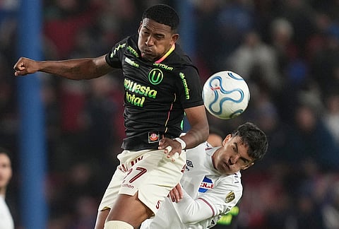 Jose Carabali of Peru's Universitario, left, and Tomas Veron of Uruguay's Nacional jump for the ball during a Copa Libertadores Group B soccer match in Montevideo, Uruguay.