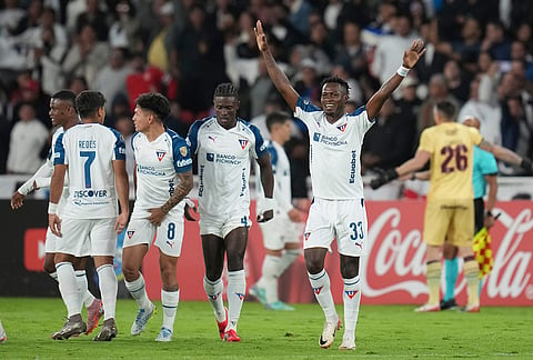 Leonel Quinonez of Ecuador's Liga Deportiva Universitaria, left, celebrates after Felipe Pena of Argentina's Lanus scored an own goal during a Copa Libertadores Group G soccer match in Quito, Ecuador.
