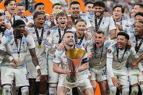 Aston Villa's John McGinn prepares to lift the trophy after the Europa League final soccer match between Freiburg and Aston Villa in Istanbul, Turkey.