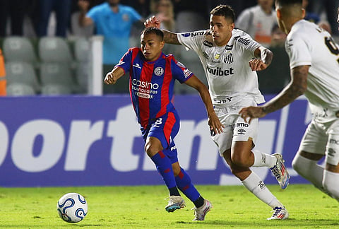 Cristian Barrios of Argentina's San Lorenzo, left, is challenged by Christian Oliva of Brazil's Santos during a Copa Sudamericana Group D soccer match in Santos, Brazil.