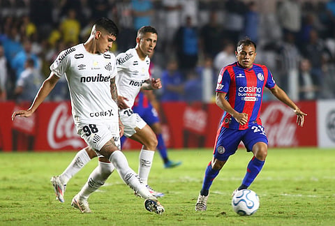Adonis Frias of Brazil's Santos, left, and Cristian Barrios of Argentina's San Lorenzo battle for the ball during a Copa Sudamericana Group D soccer match in Santos, Brazil.