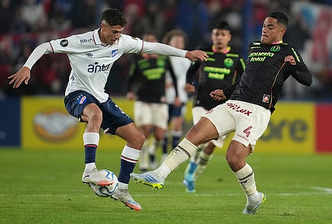 Mateo Barcia of Uruguay's Nacional, left, controls the ball challenged by Anderson Santamaria of Peru's Universitario during a Copa Libertadores Group B soccer match in Montevideo, Uruguay.