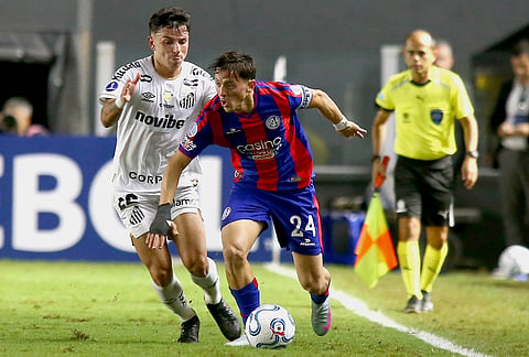 Nicolas Tripichio of Argentina's San Lorenzo, right, and Alvaro Barreal of Brazil's Santos battle for the ball during a Copa Sudamericana Group D soccer match in Santos, Brazil.