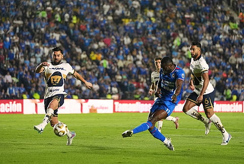 Cruz Azul's Osinachi Ebere, center, attempts a shot on goal against Pumas during the Mexican soccer league first leg final match in Mexico City.