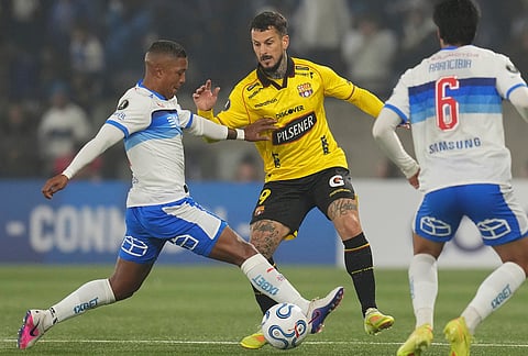 Jhojan Valencia of Chile's Universidad Catolica, left, and Dario Benedetto of Ecuador's Barcelona fight for the ball during a Copa Libertadores Group D soccer match in Santiago, Chile.