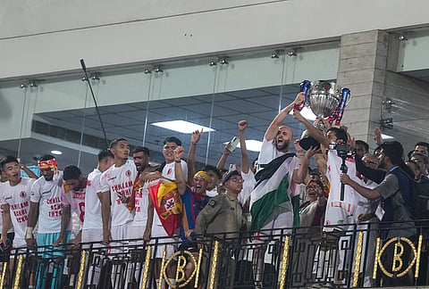 East Bengal players celebrate with the trophy after their team's victory in the Indian Super League (ISL) 2026 football match against Inter Kashi, in Kolkata.