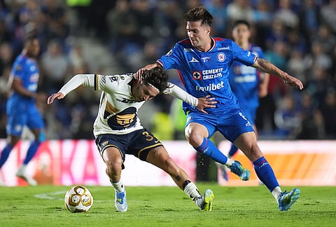Pumas' Jordan Carillo, left, and Cruz Azul's Agustin Palavecino vie for the ball during the Mexican soccer league first leg final match in Mexico City.