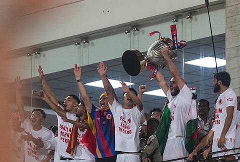 East Bengal players celebrate with the trophy after their team's victory in the Indian Super League (ISL) 2026 football match against Inter Kashi, in Kolkata.
