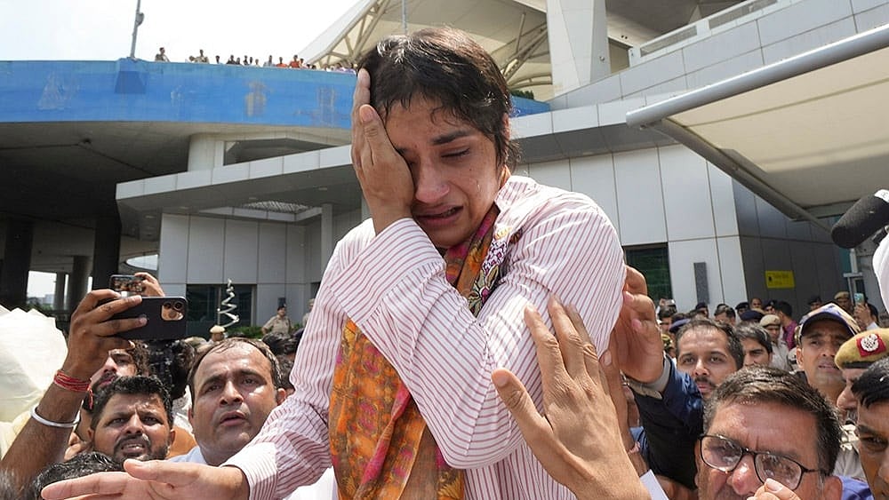 Wrestling Federation of India (WFI) issues a show-cause notice to wrestler Vinesh Phogat for alleged indiscipline and anti-doping rule violations, and barred her from domestic events till June 26th over non-compliance with UWW Anti-Doping Rules, in New Delhi. Vinesh Phogat gets emotional as she arrives after Paris Olympics heartbreak, at IGI airport, in New Delhi, in this file photo dated August 17, 2024.  - | Photo: PTI/Ravi Choudhary