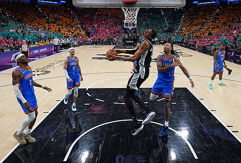 San Antonio Spurs forward Victor Wembanyama, middle, goes to the basket during the second half of Game 3 in the Western Conference finals NBA basketball playoffs series against the Oklahoma City Thunder in San Antonio. 
