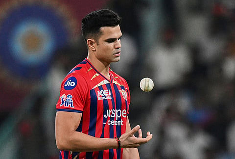 Lucknow Super Giants' Arjun Tendulkar tosses the ball during the Indian Premier League cricket match between Lucknow Super Giants and Punjab Kings, in Lucknow.