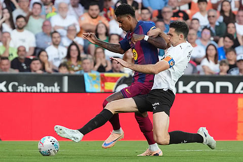 Valencia's Cesar Tarrega, right, pressures Barcelona's Marcus Rashford during the Spanish La Liga soccer match between Valencia and FC Barcelona in Valencia, Spain.