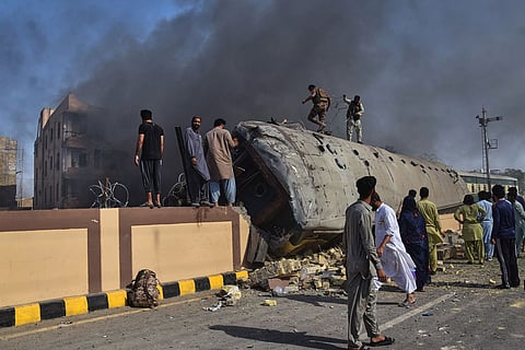 Paramilitary soldiers and volunteers try to recover victims from an overturned train coach on a railway track at the site of a bomb explosion in Quetta, Pakistan.