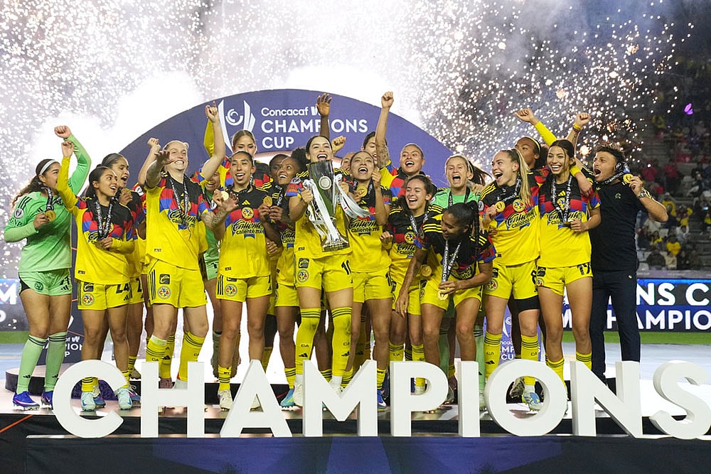Scarlett Camberos of Mexico's America, center, lifts the trophy after winning the Women's CONCACAF Champions Cup final soccer match against The United States' Washington Spirit in Pachuca, Mexico. - | Photo: AP/Fernando Llano