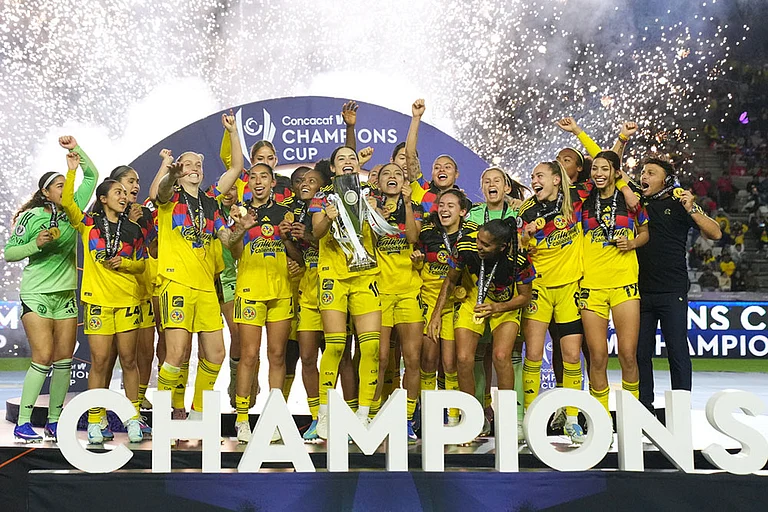 Scarlett Camberos of Mexico's America, center, lifts the trophy after winning the Women's CONCACAF Champions Cup final soccer match against The United States' Washington Spirit in Pachuca, Mexico. - | Photo: AP/Fernando Llano
