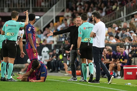 Barcelona's head coach Hansi Flick, third from right, protests during the Spanish La Liga soccer match between Valencia and FC Barcelona in Valencia, Spain.
