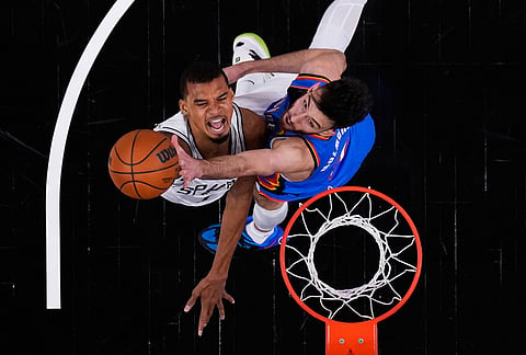 San Antonio Spurs forward Victor Wembanyama, left, scores against Oklahoma City Thunder center Chet Holmgren, right, during the first half in Game 4 in the Western Conference finals NBA basketball playoffs series in San Antonio.